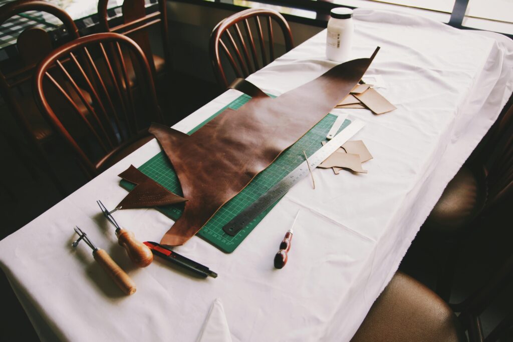 Intricate leather crafting setup with tools on a workshop table in Jakarta.